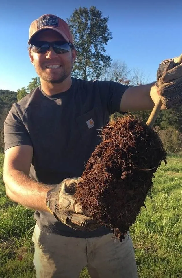 A man holding dirt in his hands.